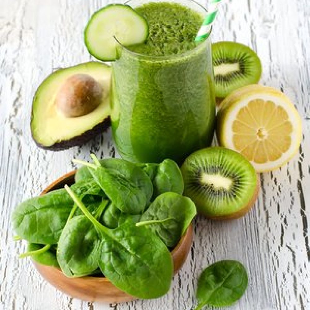 Fresh green detox smoothie with avocadi and spinach on white wooden background, diet and health concept, vitamins