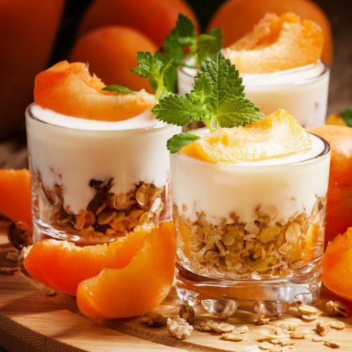 Homemade granola with yogurt and apricot in glass bowls, healthy breakfast, selective focus