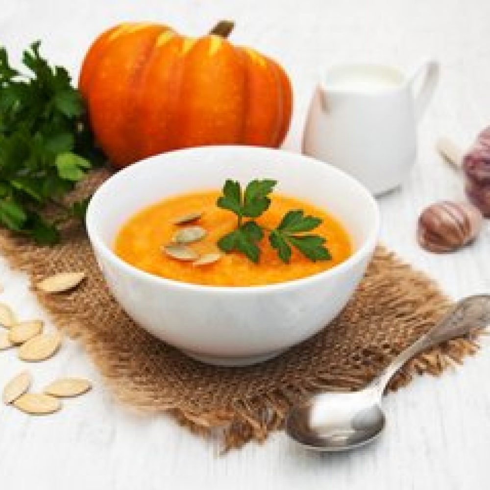 Bowl with Pumpkin soup on a old wooden background