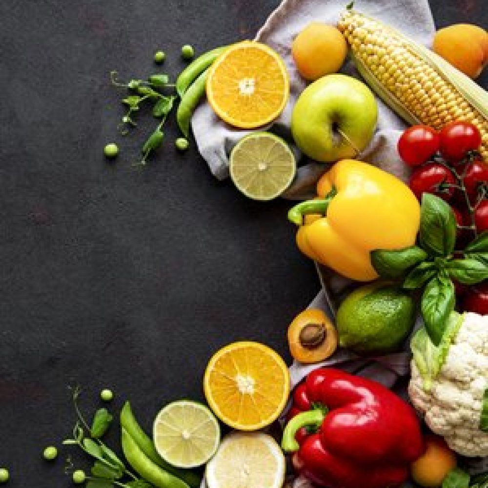 Healthy food. Vegetables and fruits on a black concrete background. Top view. Copy space.